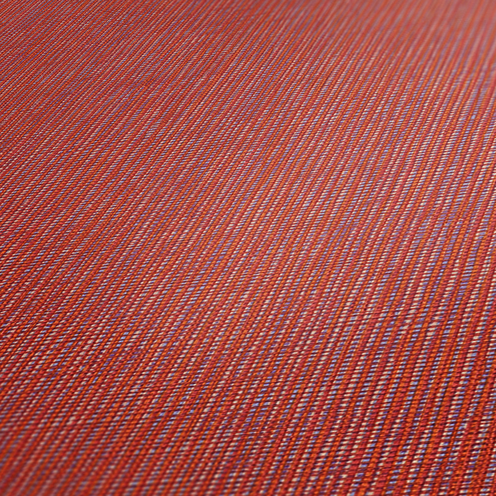             Papel pintado rojo con estampado textil en rojo, naranja y morado
        