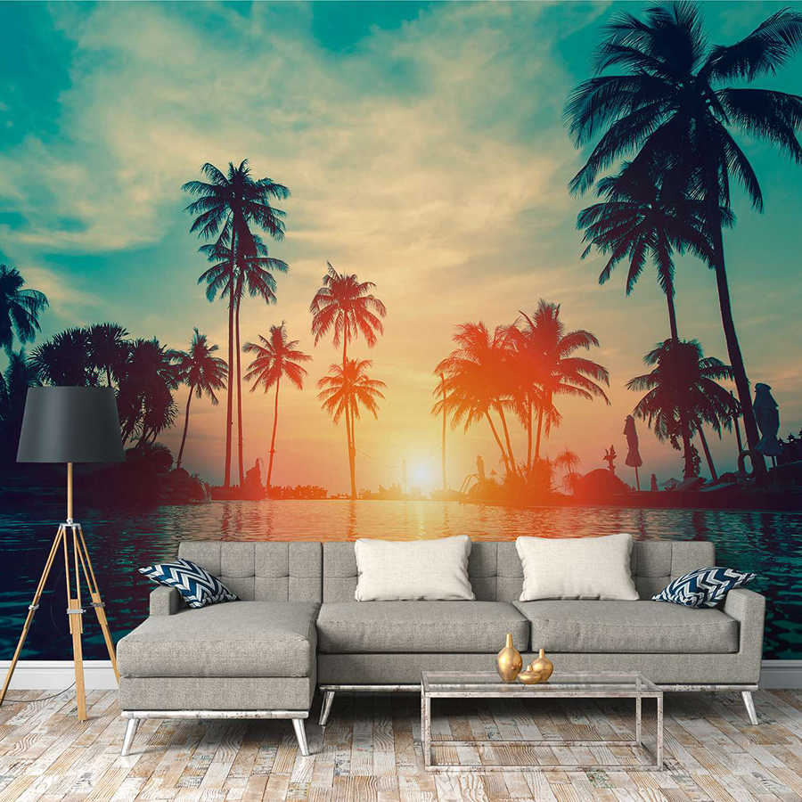 Papier peint panoramique avec des palmiers au bord de l'eau au coucher du soleil - bleu, orange, noir
