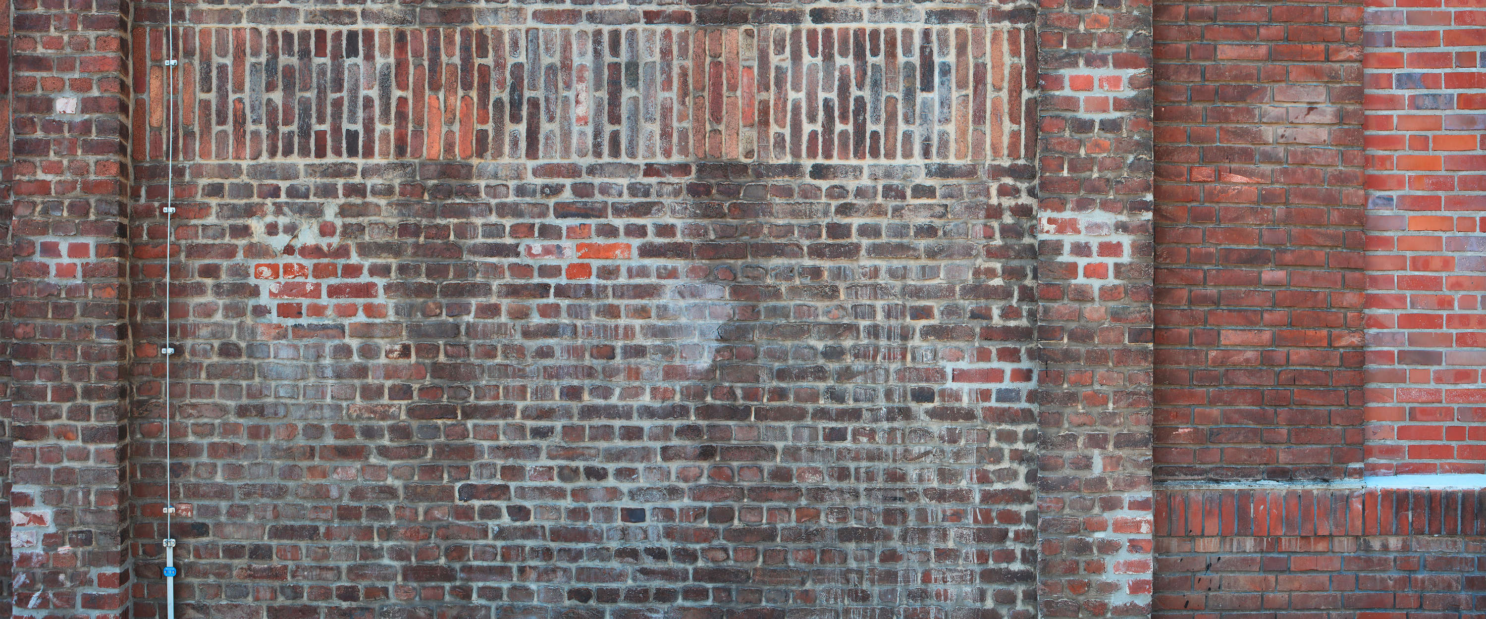             Papier peint panoramique mur de briques rouges style industriel
        