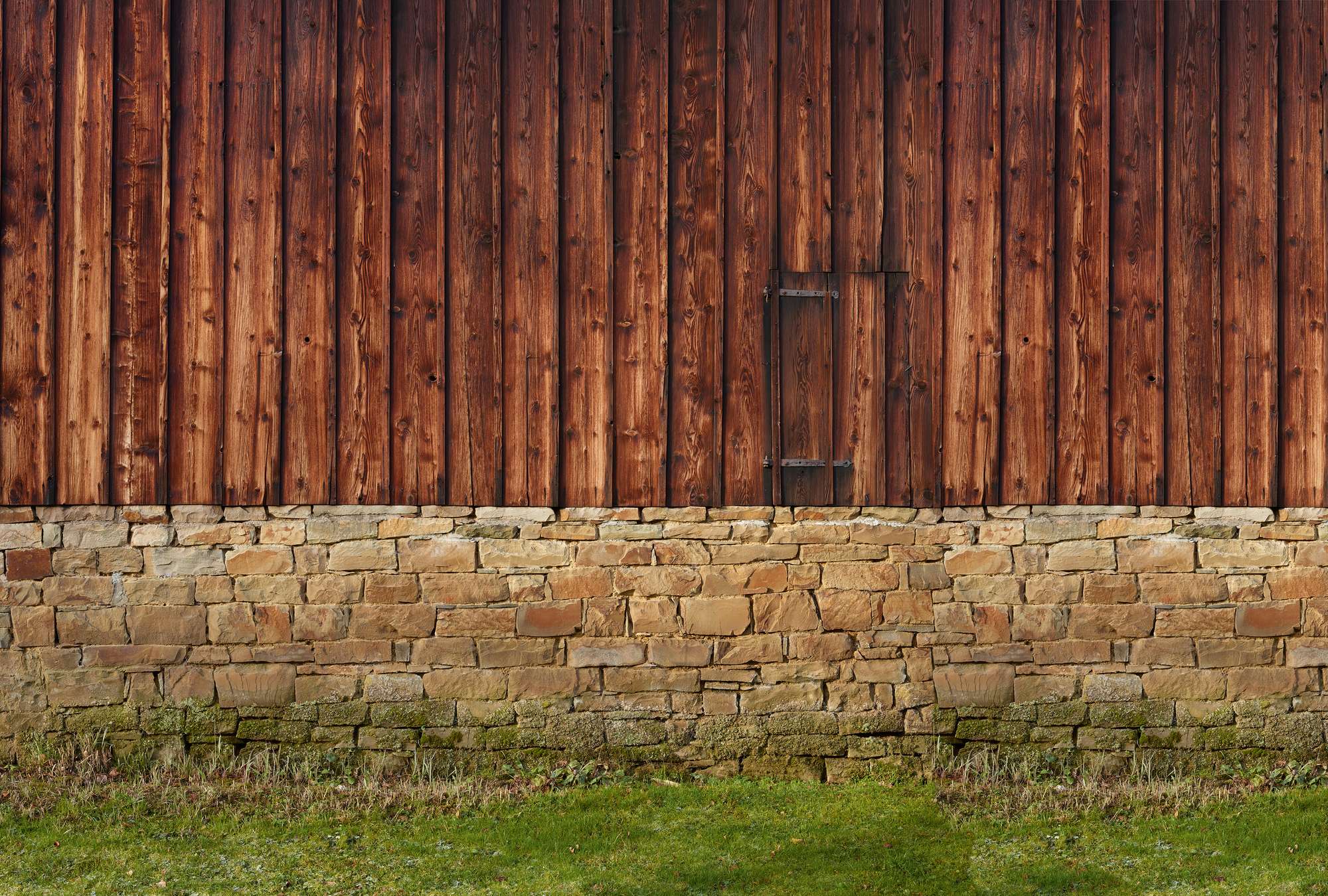             Carta da parati fotografica con facciata in legno e parete in pietra naturale
        
