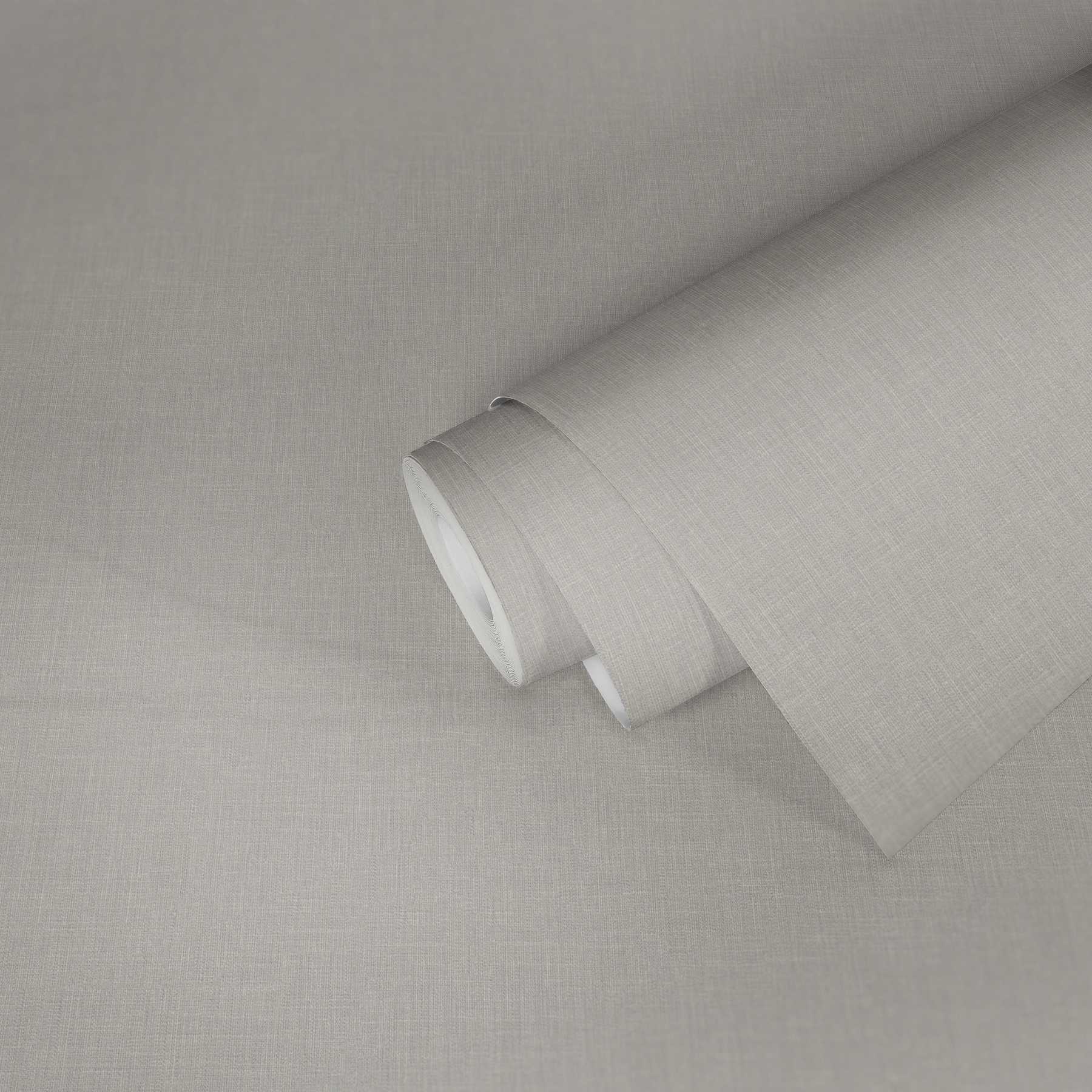            Carta da parati in tessuto non tessuto grigio chiaro con aspetto tessile e motivo strutturato
        