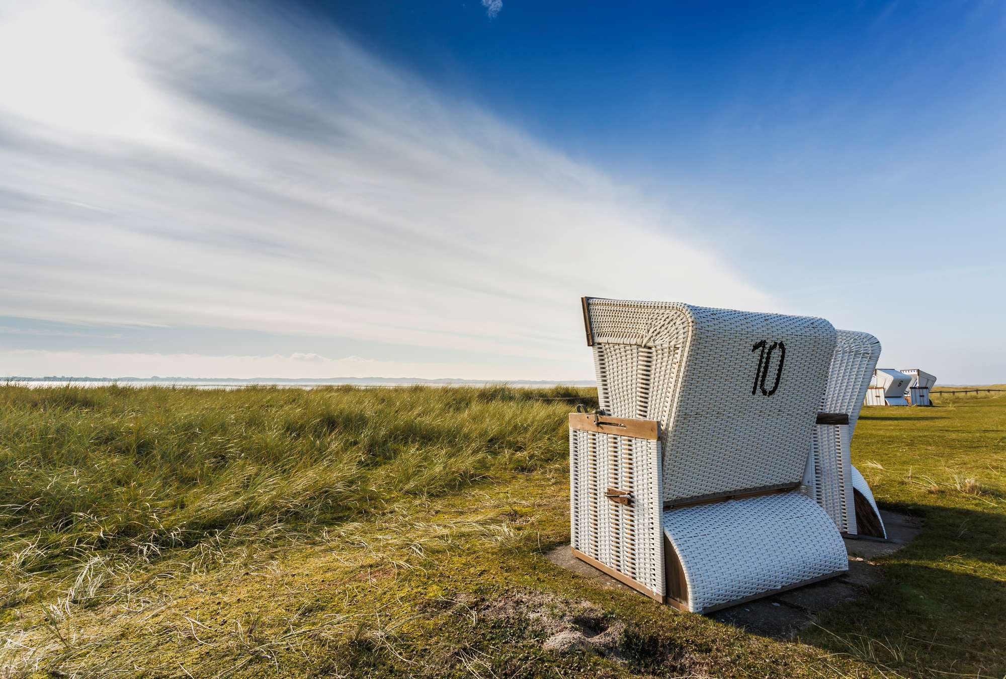             Mural de sillas de playa en las dunas
        
