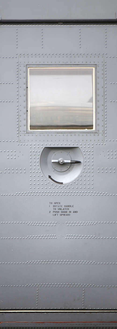             Papier peint panoramique moderne porte d'avion sur intissé nacré lisse
        
