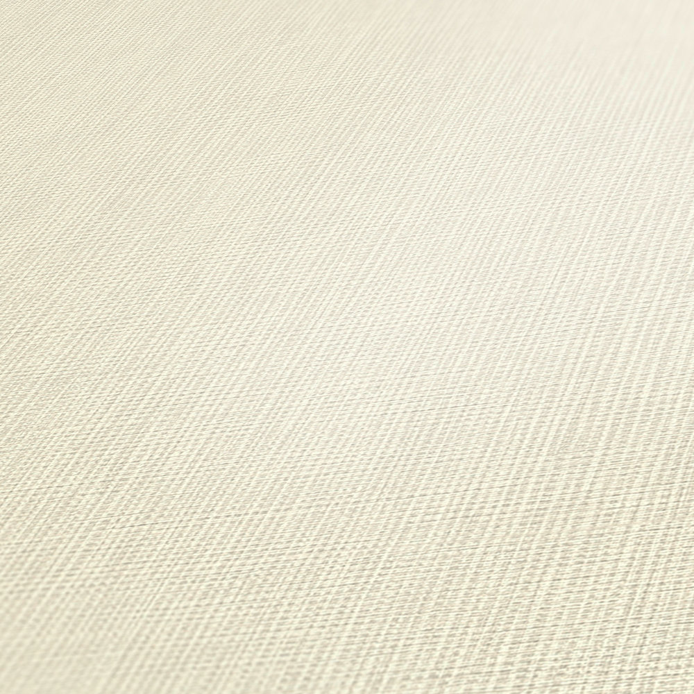             Vliesbehang crème mat ivoor met textielstructuur
        