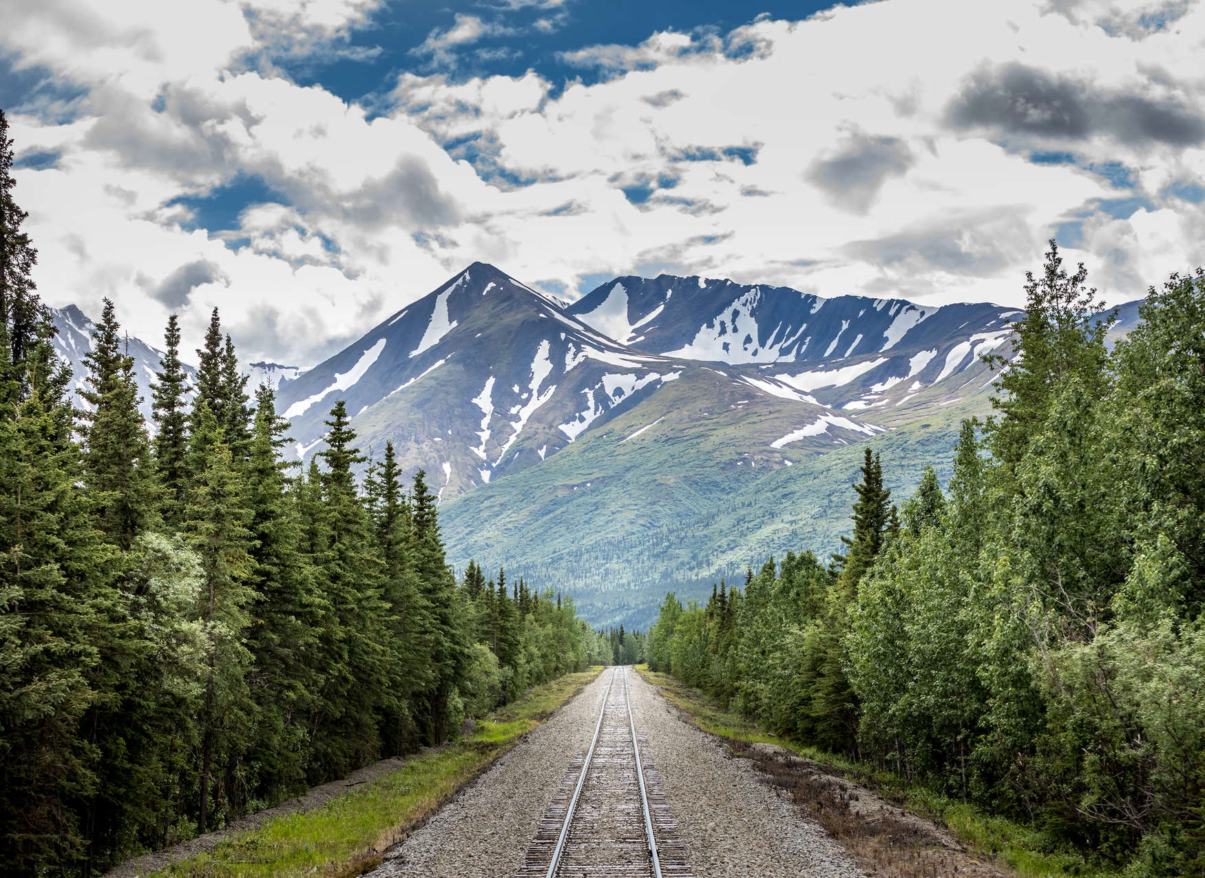             Papier peint panoramique avec voie ferrée traversant une forêt à la montagne - vert, bleu, gris
        