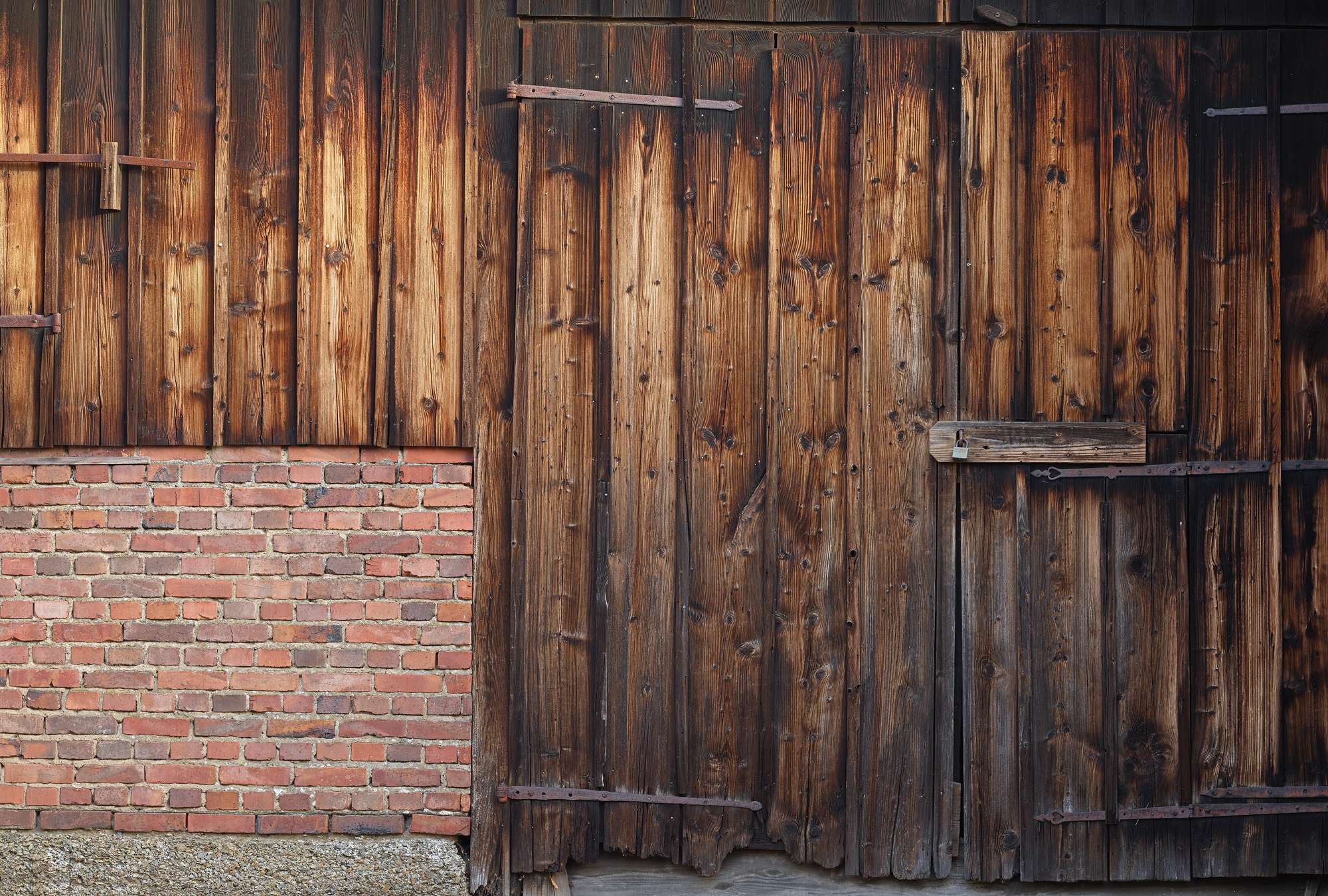             Photo wallpaper red brick wall with wooden planks and barn door
        