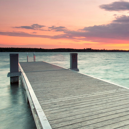Photo wallpaper wooden jetty in the water at sunset
