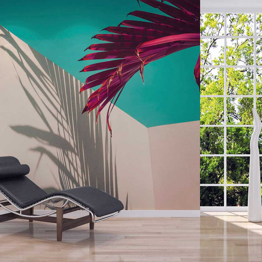 Fotomurali con foglia di palma e ombra su parete in cemento - viola, turchese, bianco
