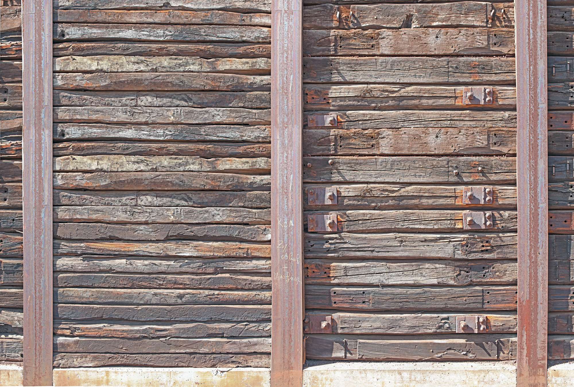             Papel pintado con tablones de madera rústica entre vigas de acero
        