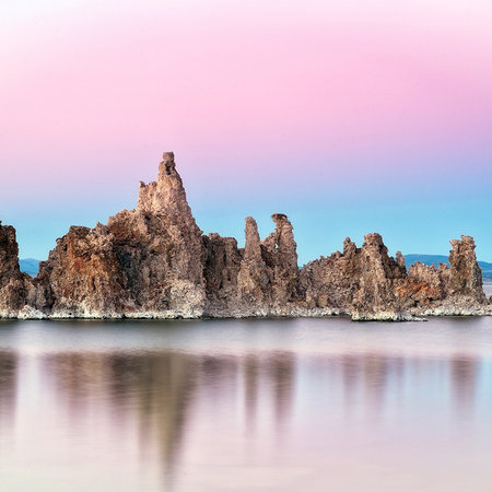 Photo wallpaper rocks in reflecting water with pink sky
